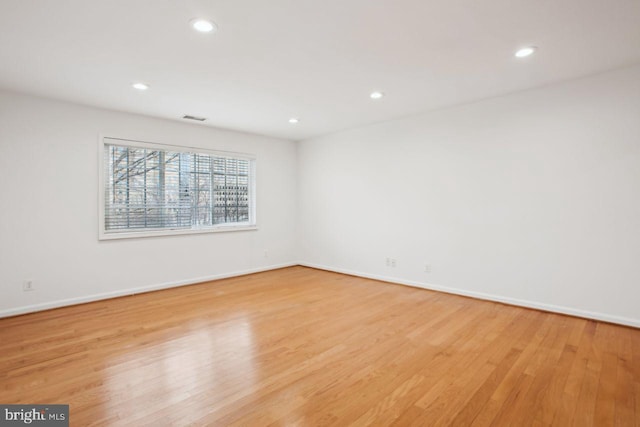 unfurnished room featuring baseboards, light wood-type flooring, visible vents, and recessed lighting