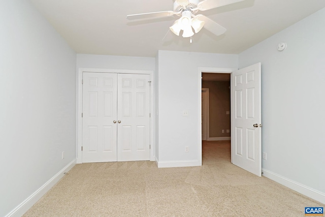 unfurnished bedroom with a ceiling fan, a closet, light colored carpet, and baseboards