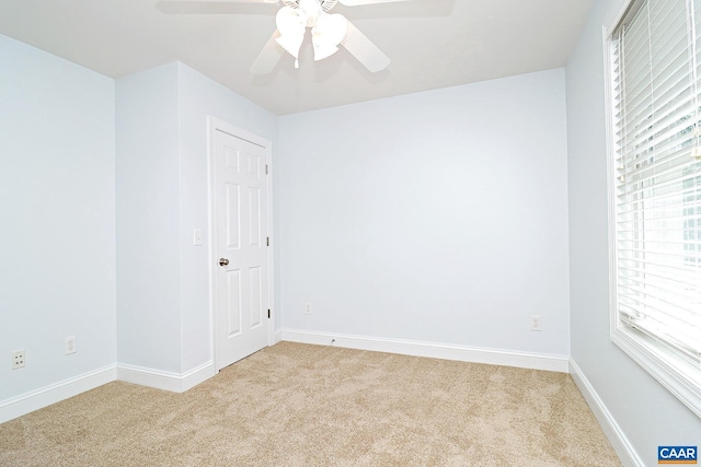 carpeted spare room with ceiling fan and baseboards