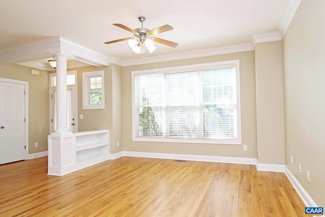 spare room featuring ceiling fan, baseboards, light wood-style floors, decorative columns, and crown molding