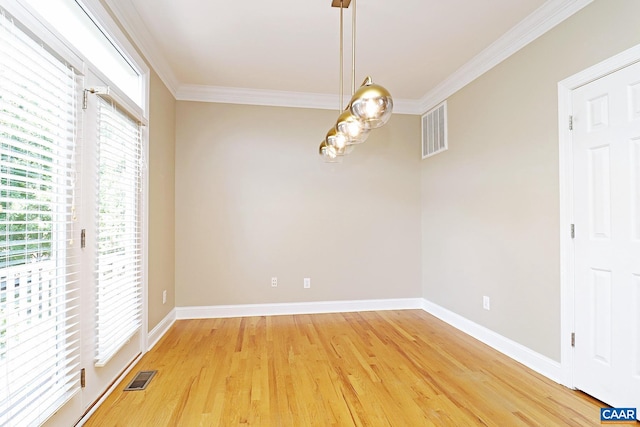 unfurnished dining area with ornamental molding, wood finished floors, visible vents, and baseboards