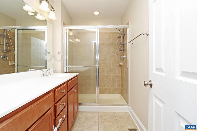 bathroom featuring a stall shower, tile patterned flooring, vanity, and baseboards