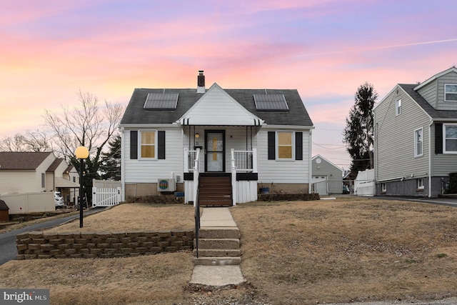 view of front of property featuring a porch, a yard, fence, and a chimney