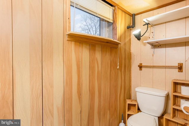 bathroom with wooden walls and toilet