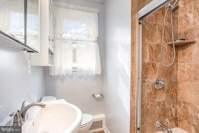 full bath featuring visible vents, a sink, a tile shower, and toilet