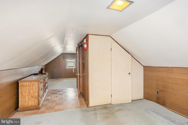 additional living space with lofted ceiling and wooden walls