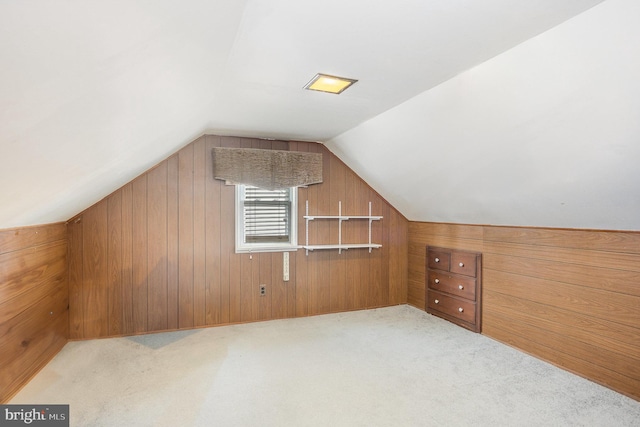 bonus room with wooden walls, vaulted ceiling, and light colored carpet