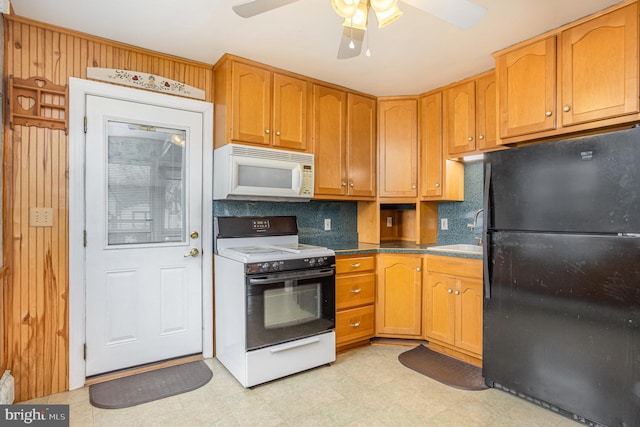 kitchen featuring white appliances, a sink, a ceiling fan, light floors, and dark countertops