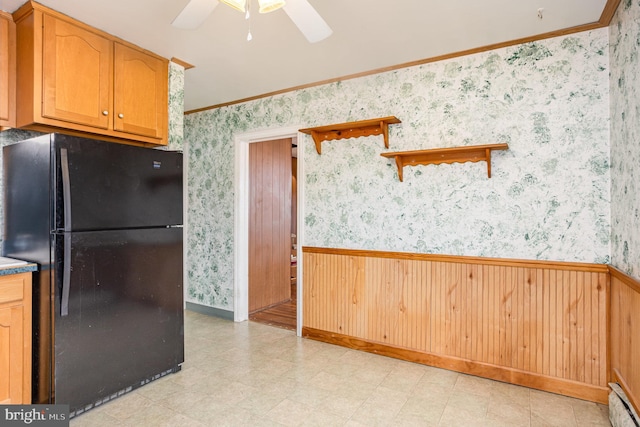 kitchen featuring a wainscoted wall, freestanding refrigerator, and wallpapered walls