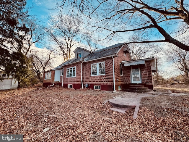 rear view of property featuring entry steps and brick siding