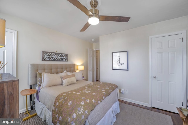 bedroom featuring ceiling fan, baseboards, and wood finished floors