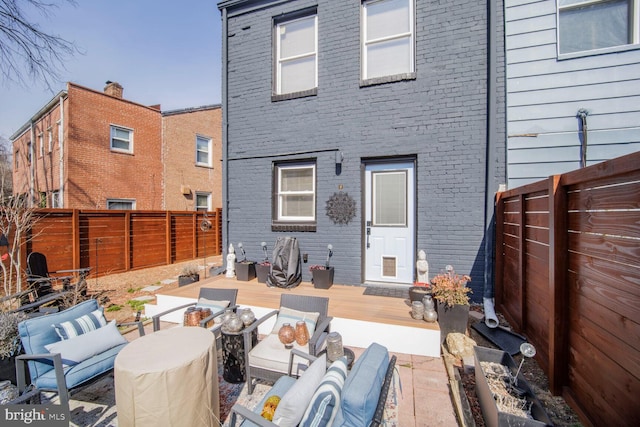 back of house with brick siding and a fenced backyard