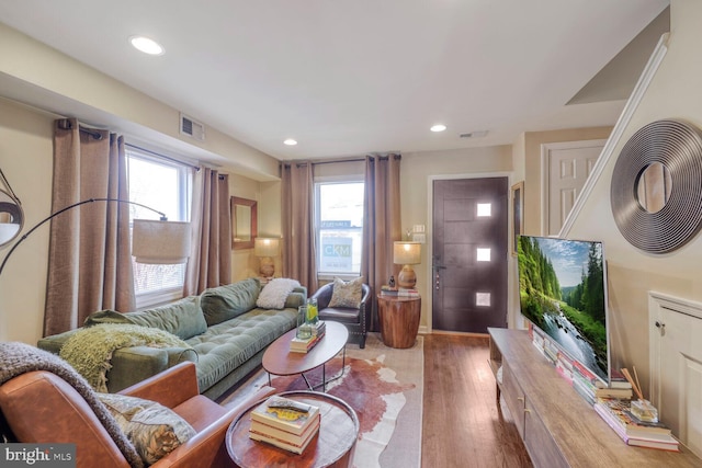 living area with a wealth of natural light, wood finished floors, visible vents, and recessed lighting