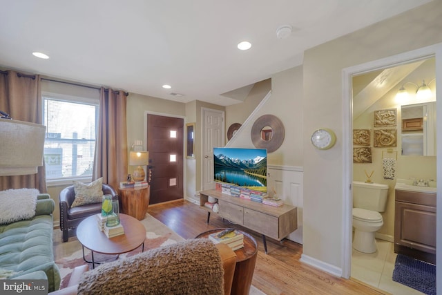 living room featuring light wood-style floors, wainscoting, and recessed lighting