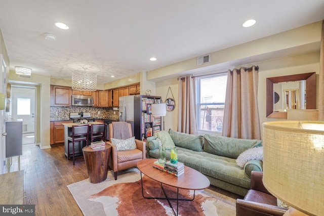 living area with recessed lighting, dark wood-style flooring, and visible vents