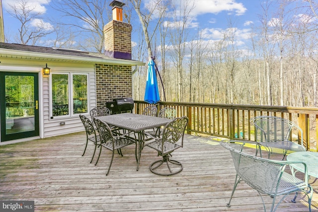 deck featuring outdoor dining area and a grill