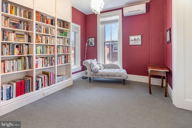 sitting room featuring baseboards, an AC wall unit, carpet, and crown molding