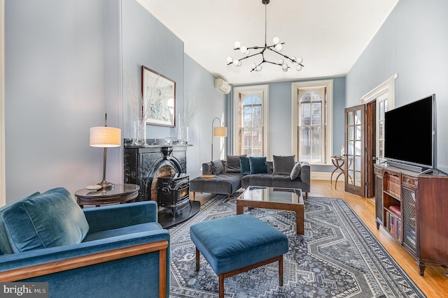 living area with light wood-style floors, an inviting chandelier, and a wall mounted AC