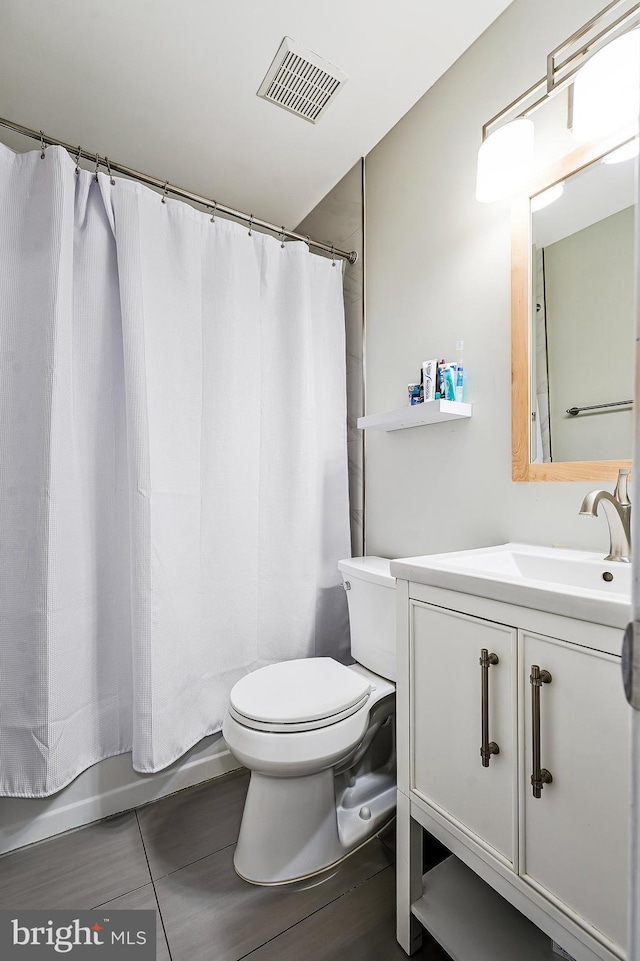 bathroom with toilet, shower / tub combo, visible vents, and vanity