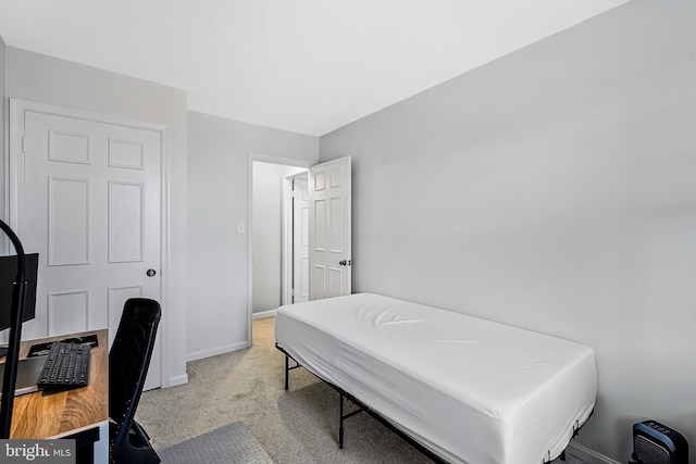 bedroom featuring light carpet and baseboards