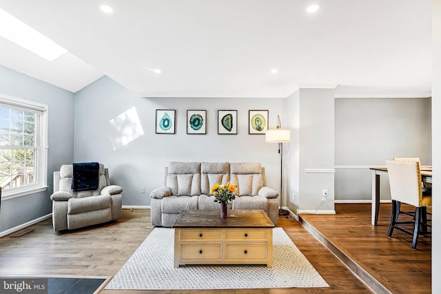 living area featuring light wood-type flooring, baseboards, and recessed lighting