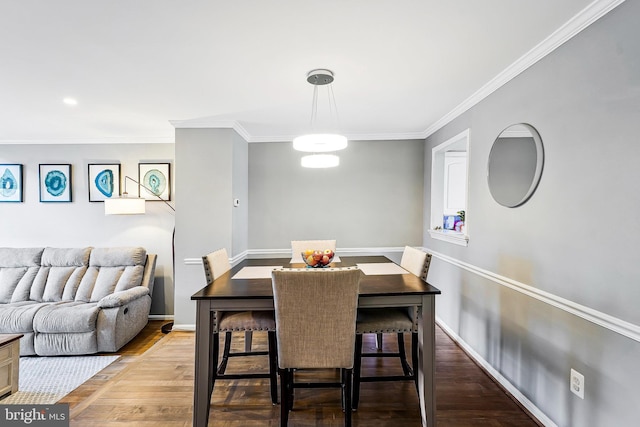 dining area with crown molding, baseboards, and wood finished floors