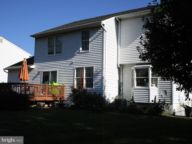 rear view of house featuring cooling unit and a wooden deck