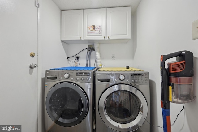 laundry area with washing machine and clothes dryer and cabinet space