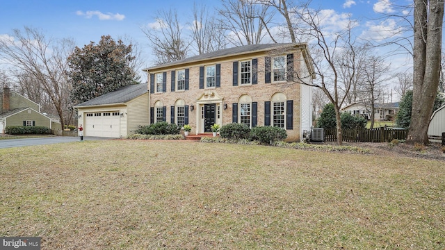 view of front facade with driveway, a garage, fence, a front yard, and brick siding