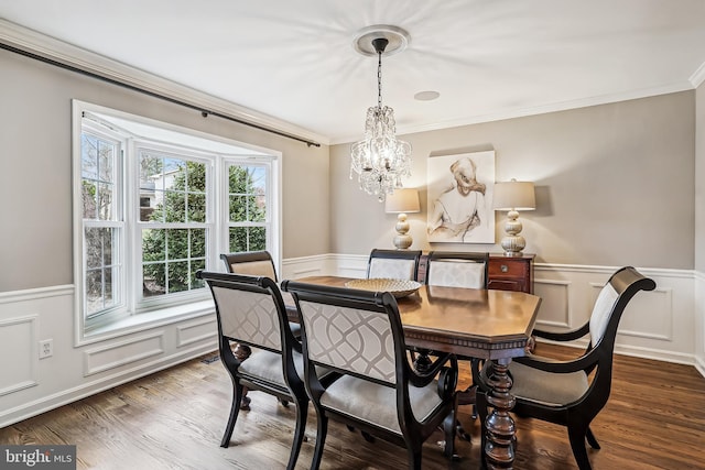 dining space featuring a wainscoted wall, crown molding, and wood finished floors