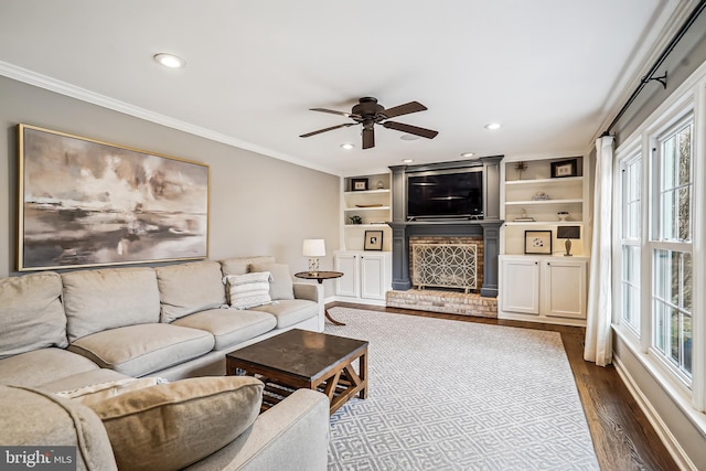 living room featuring dark wood-style floors, a fireplace, crown molding, and recessed lighting