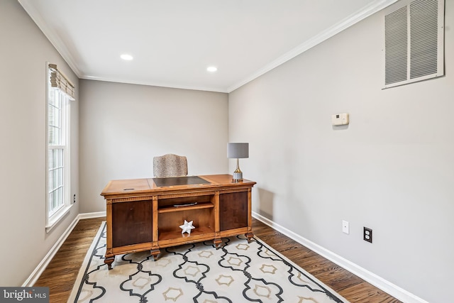 office space with ornamental molding, visible vents, baseboards, and wood finished floors