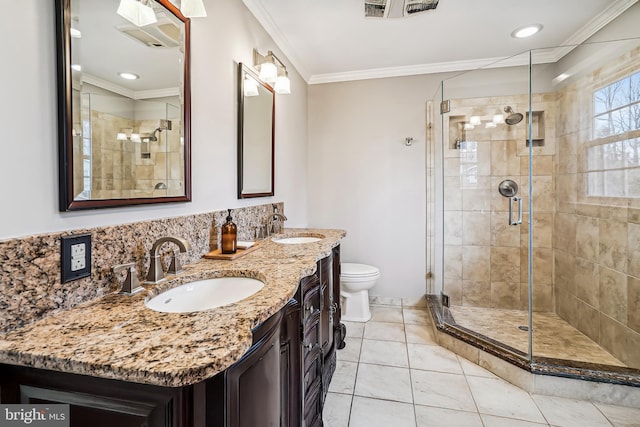 full bath featuring crown molding, a stall shower, and a sink