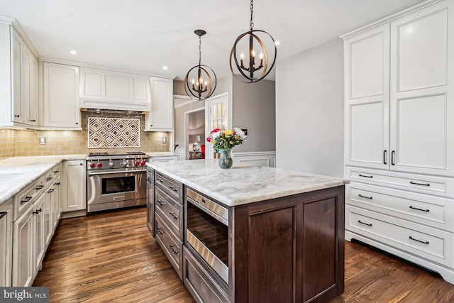 kitchen featuring stainless steel appliances, dark wood finished floors, white cabinetry, and decorative backsplash