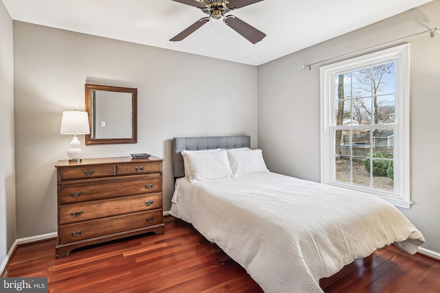 bedroom featuring ceiling fan, baseboards, and dark wood-style flooring