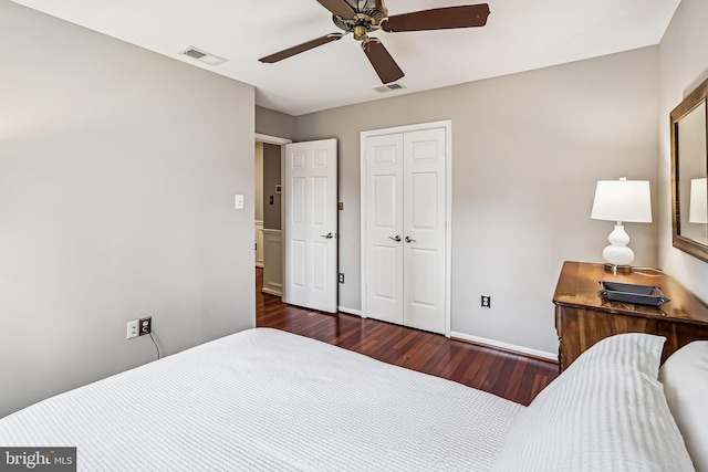 bedroom featuring dark wood-style floors, baseboards, visible vents, and a closet