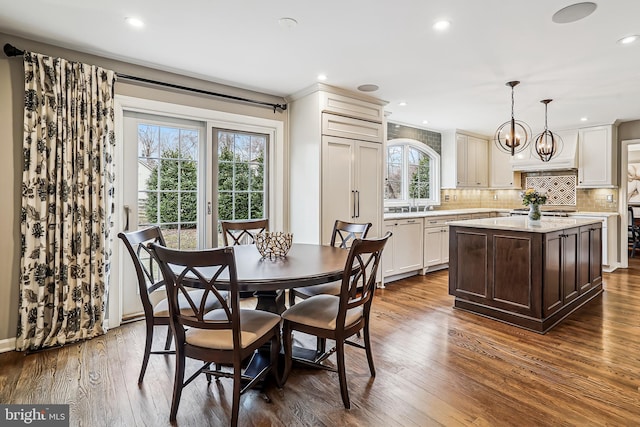 dining area featuring recessed lighting, dark wood-style flooring, and an inviting chandelier