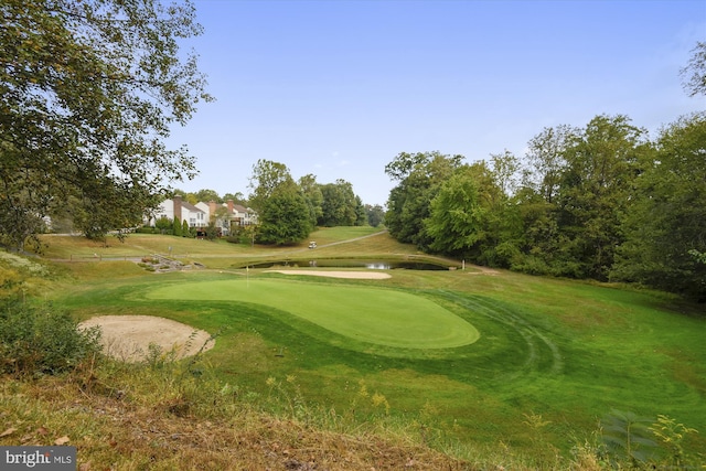 view of property's community featuring view of golf course and a lawn