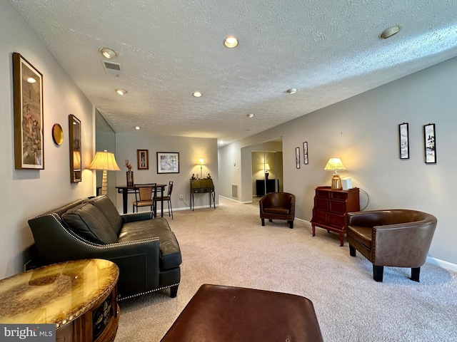 living room with baseboards, visible vents, light colored carpet, a textured ceiling, and recessed lighting