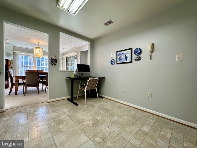 office space with stone tile floors and baseboards