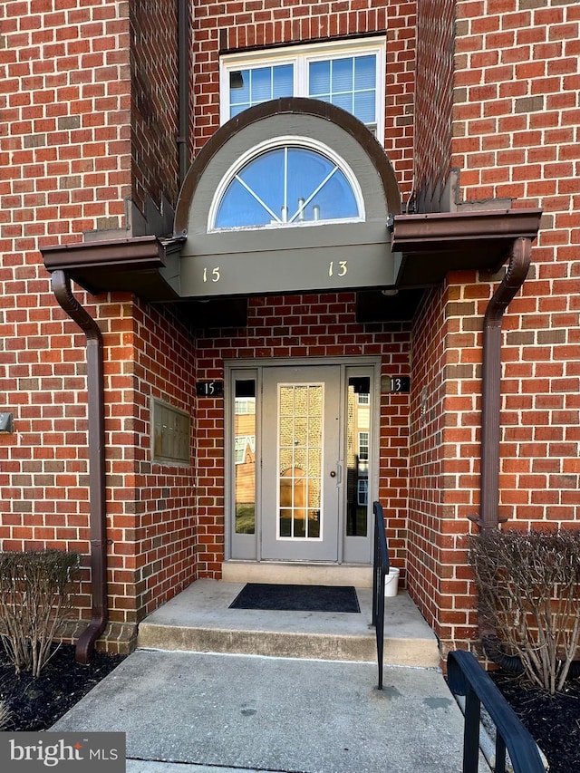 property entrance featuring brick siding