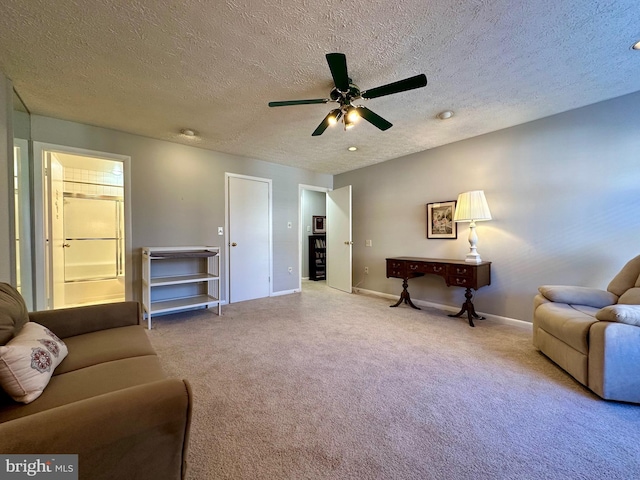 sitting room with ceiling fan, baseboards, a textured ceiling, and light colored carpet