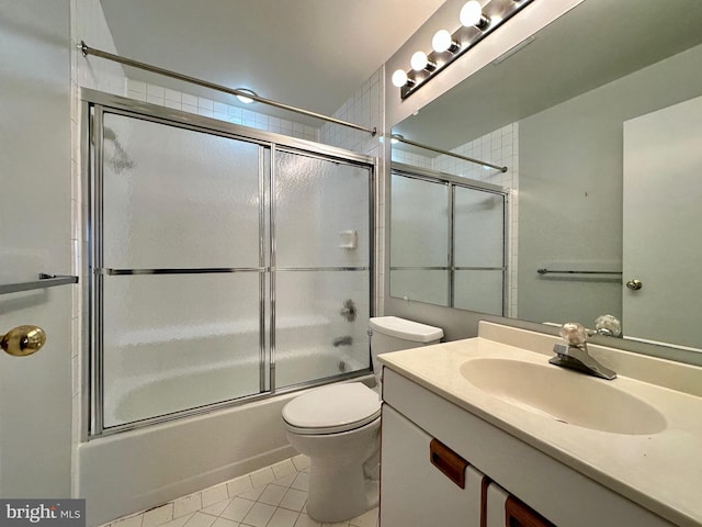 full bath with combined bath / shower with glass door, vanity, toilet, and tile patterned floors