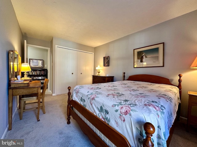 carpeted bedroom featuring a closet, a textured ceiling, and baseboards