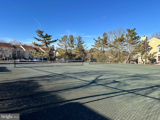 view of sport court with fence and a residential view