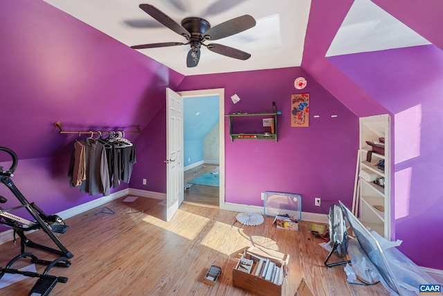 interior space featuring vaulted ceiling, light wood-style flooring, baseboards, and ceiling fan