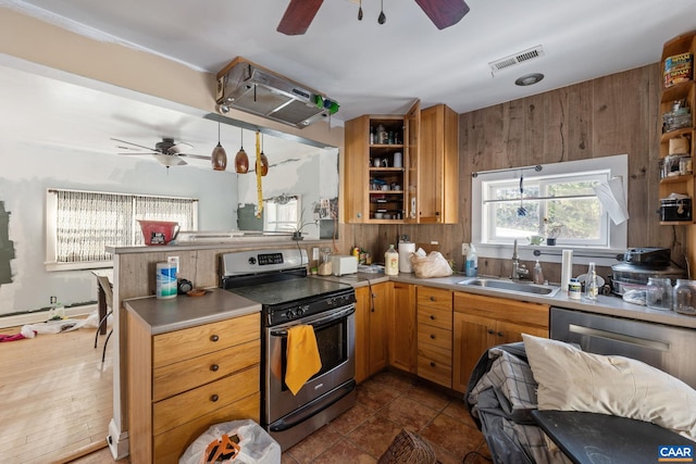 kitchen with brown cabinets, electric stove, visible vents, and a sink