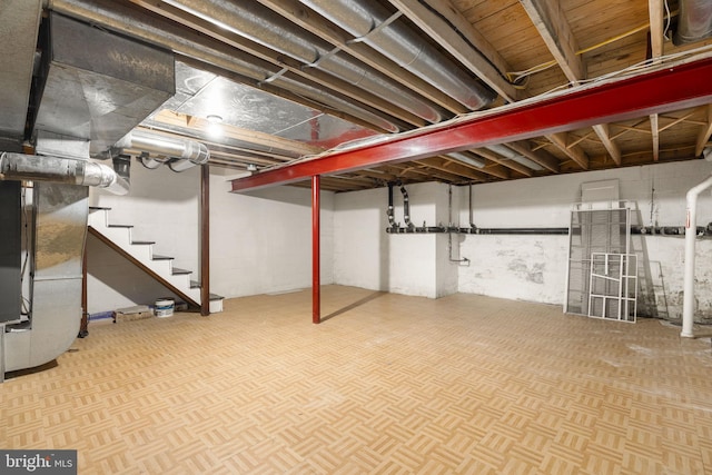 below grade area featuring heating unit and stairs