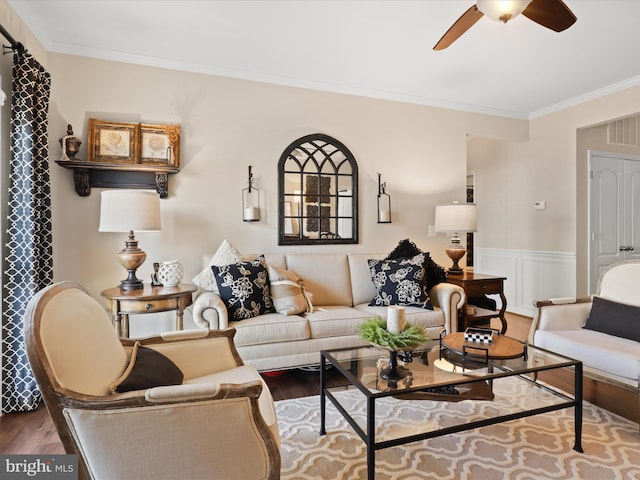 living area featuring visible vents, ornamental molding, wainscoting, ceiling fan, and wood finished floors