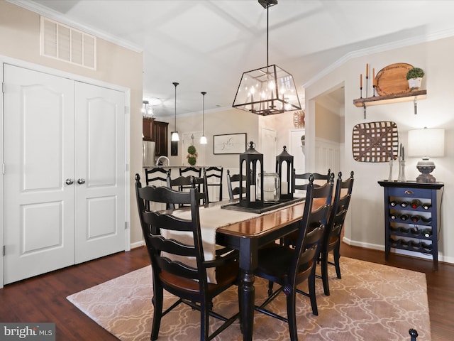 dining space with dark wood finished floors, crown molding, visible vents, a chandelier, and baseboards